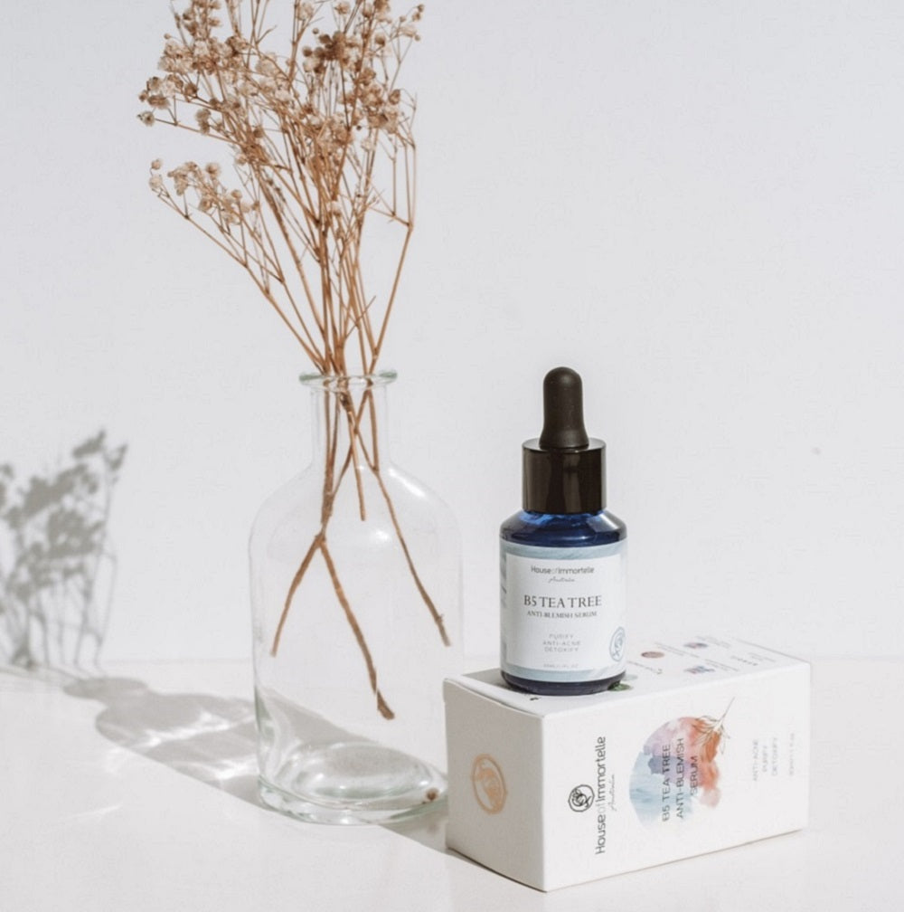 House of Immortelle B5 Tea Tree Anti-Blemish Serum bottle with a sleek design and dropper cap. The serum is formulated to target blemishes and improve skin clarity, featuring key ingredients like tea tree oil and vitamin B5 for clear, balanced skin