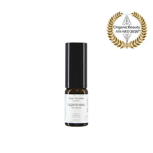 A potent Tightening Eye Cream by House of Immortelle, formulated to firm and smooth the delicate skin around the eyes. This rich cream helps reduce the appearance of fine lines, puffiness, and dark circles, leaving the eyes looking rejuvenated and refreshed. Packaged in a luxurious container for daily use.