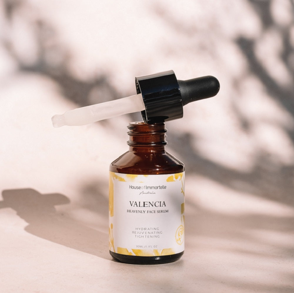 House of Immortelle Valencia Heavenly Face Serum in a sleek, elegant bottle, featuring a lightweight formula designed to hydrate and nourish the skin. The serum is infused with natural ingredients, offering a glowing, refreshed complexion, and is ideal for daily skincare routines